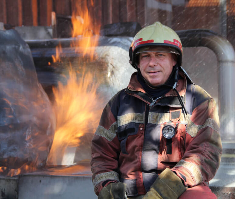 ein Feuerwehrmann, der vor einem Feuer steht