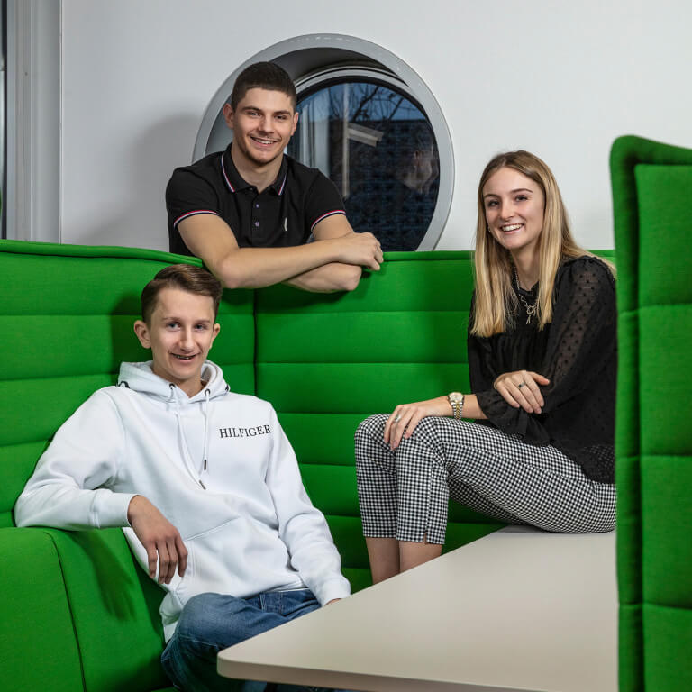 drei junge Leute sitzen auf einem grünen Sofa im GVZ